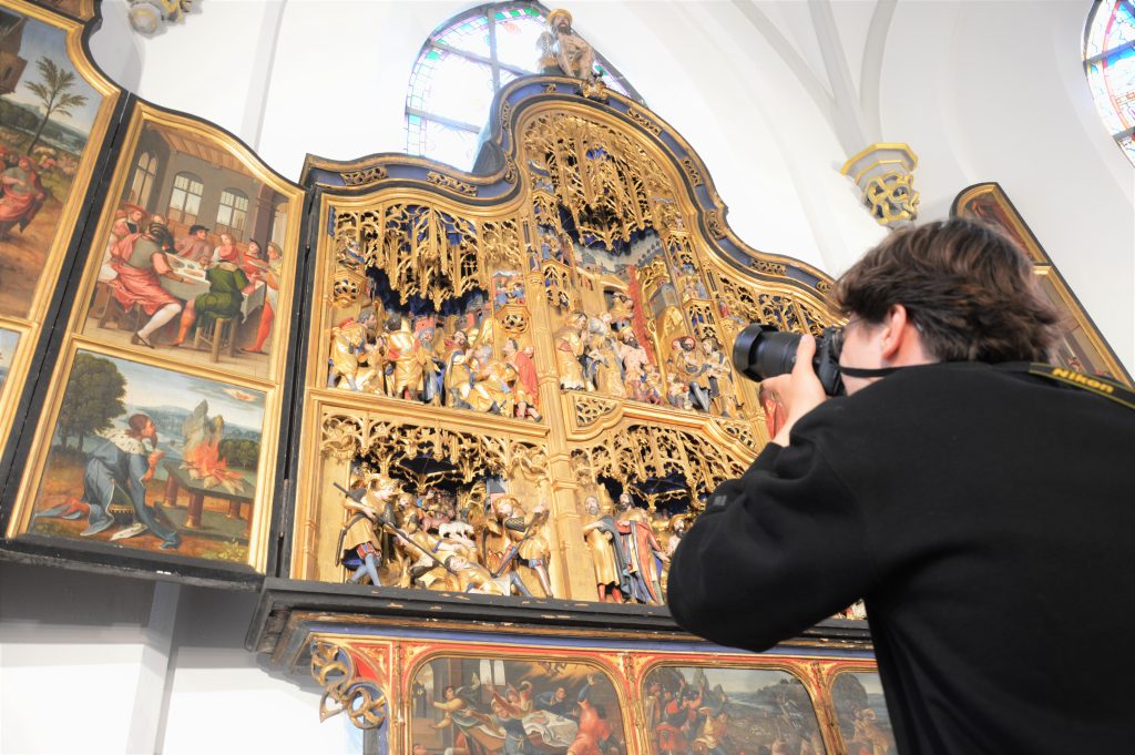 Een van de jongeren vrijwilligers, Tim Emmers, terwijl hij het Sint-Job retabel uit de Kerk van Schoonbroek (Retie) fotografeert. 