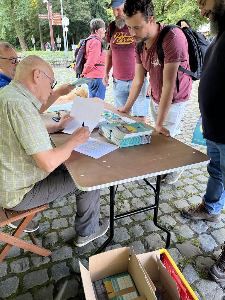 Karel en Rik van het Vlaams Compostelagenootschap ontvangen de eerste wandelaars aan de Abdij van Postel.